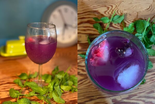 Purple mocktail with a sugar mint rim around the wine glass
